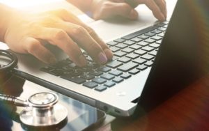 Doctor working on laptop | MyTeleMed | TeleMed Inc.