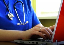 Woman Nurse Typing on laptop | TeleMed Inc.